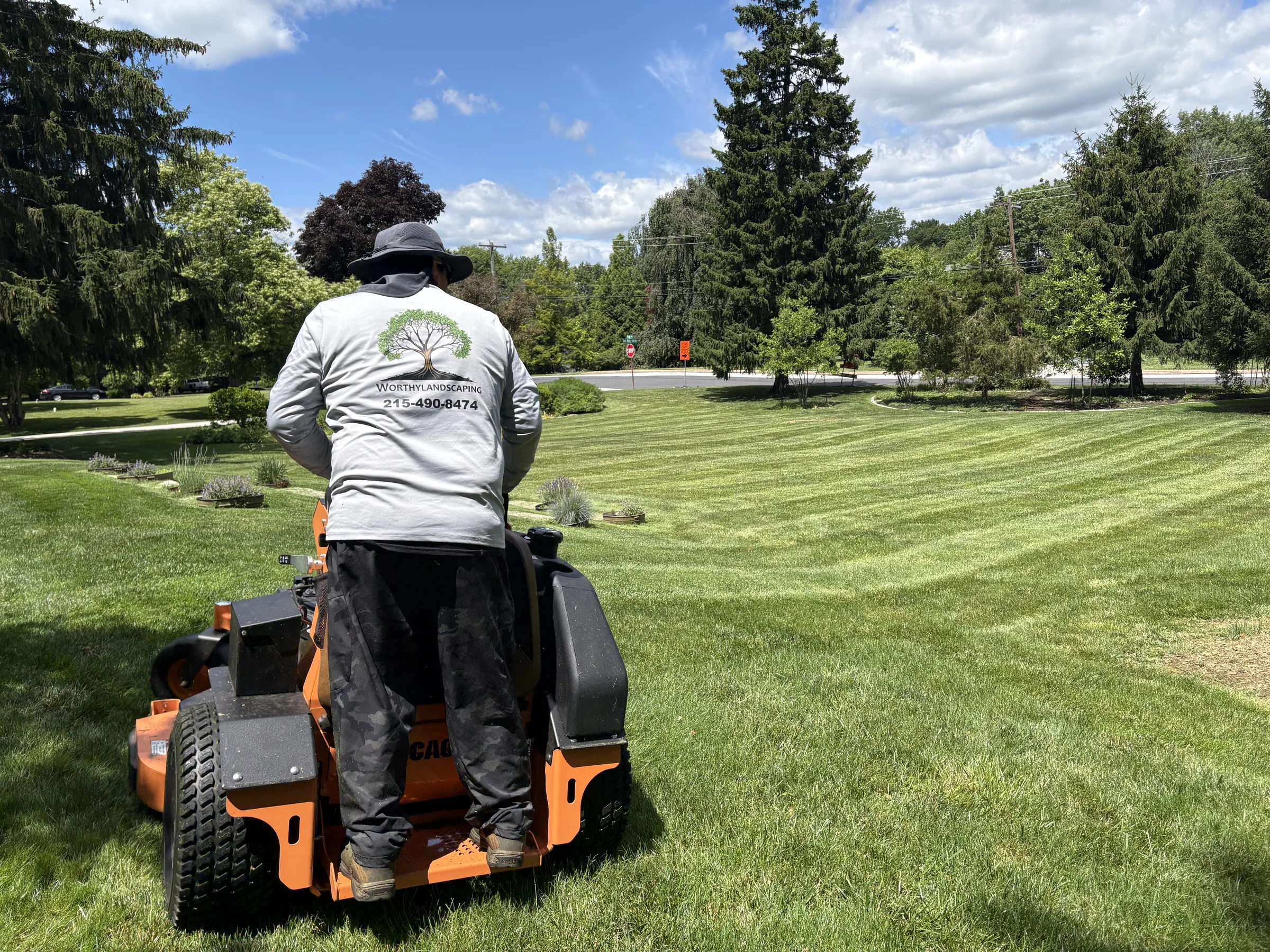 Worthy Landscaping crew member mowing a large Chester County lawn