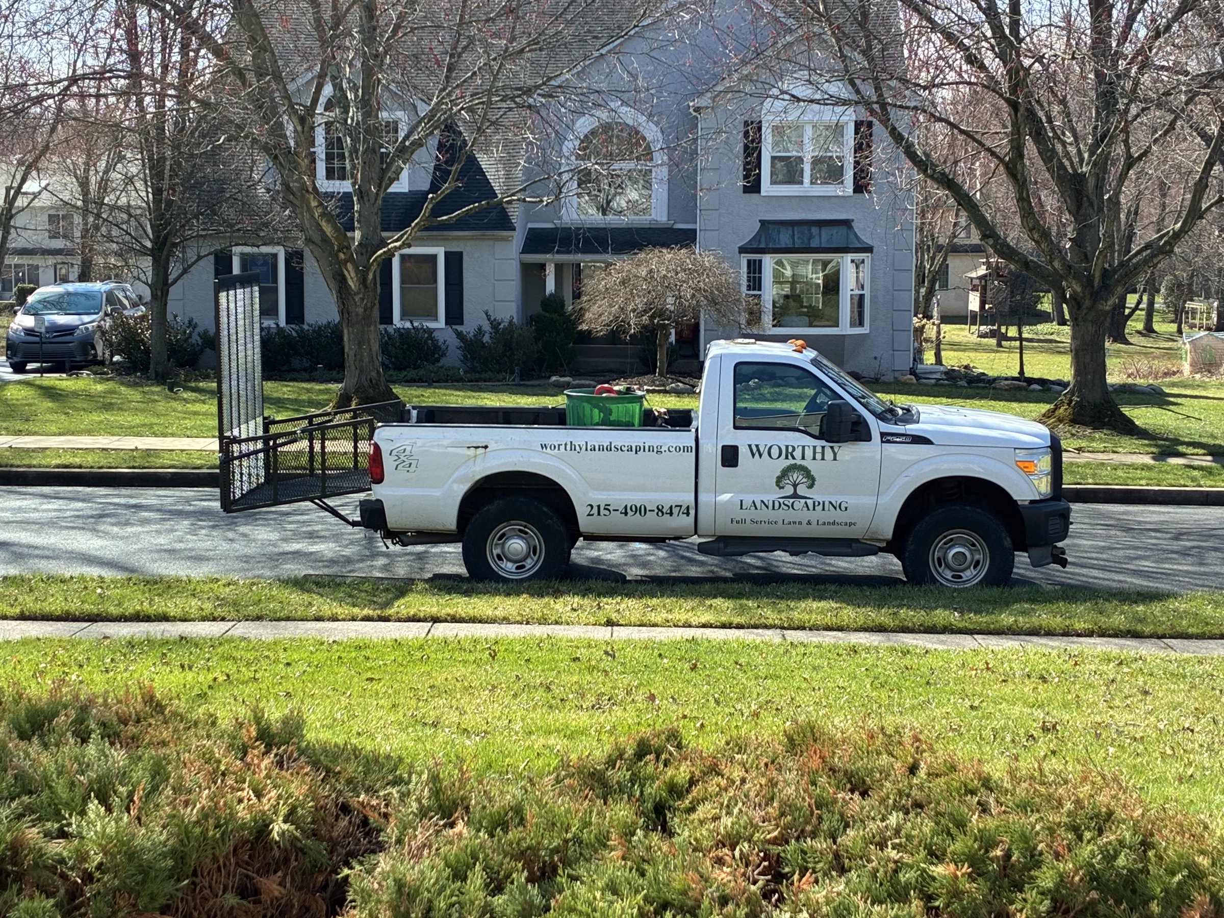 Worthy Landscaping branded truck at a residential property